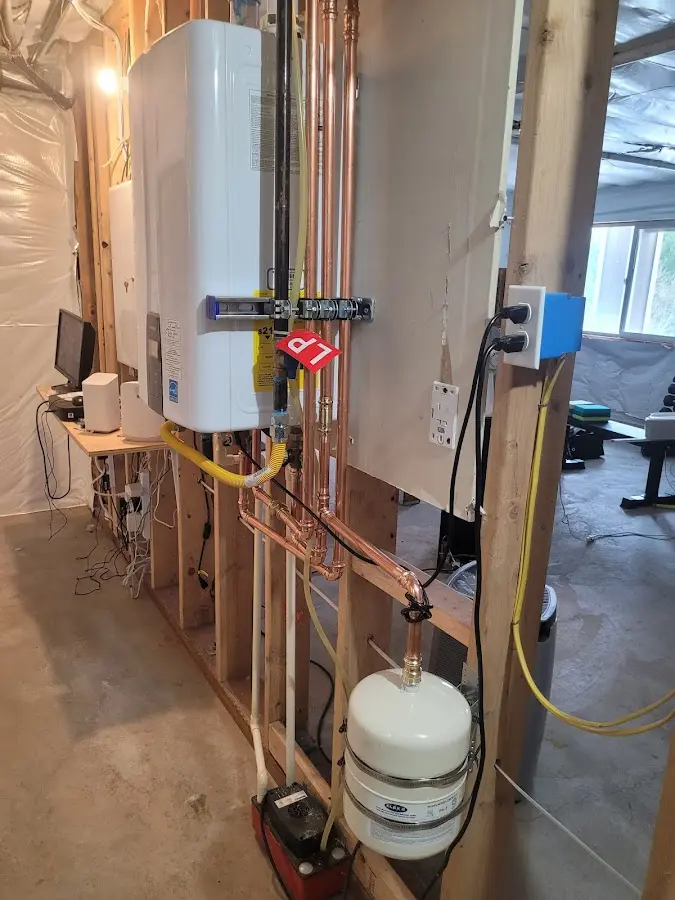 Licensed plumber repairing a kitchen sink in Ayer